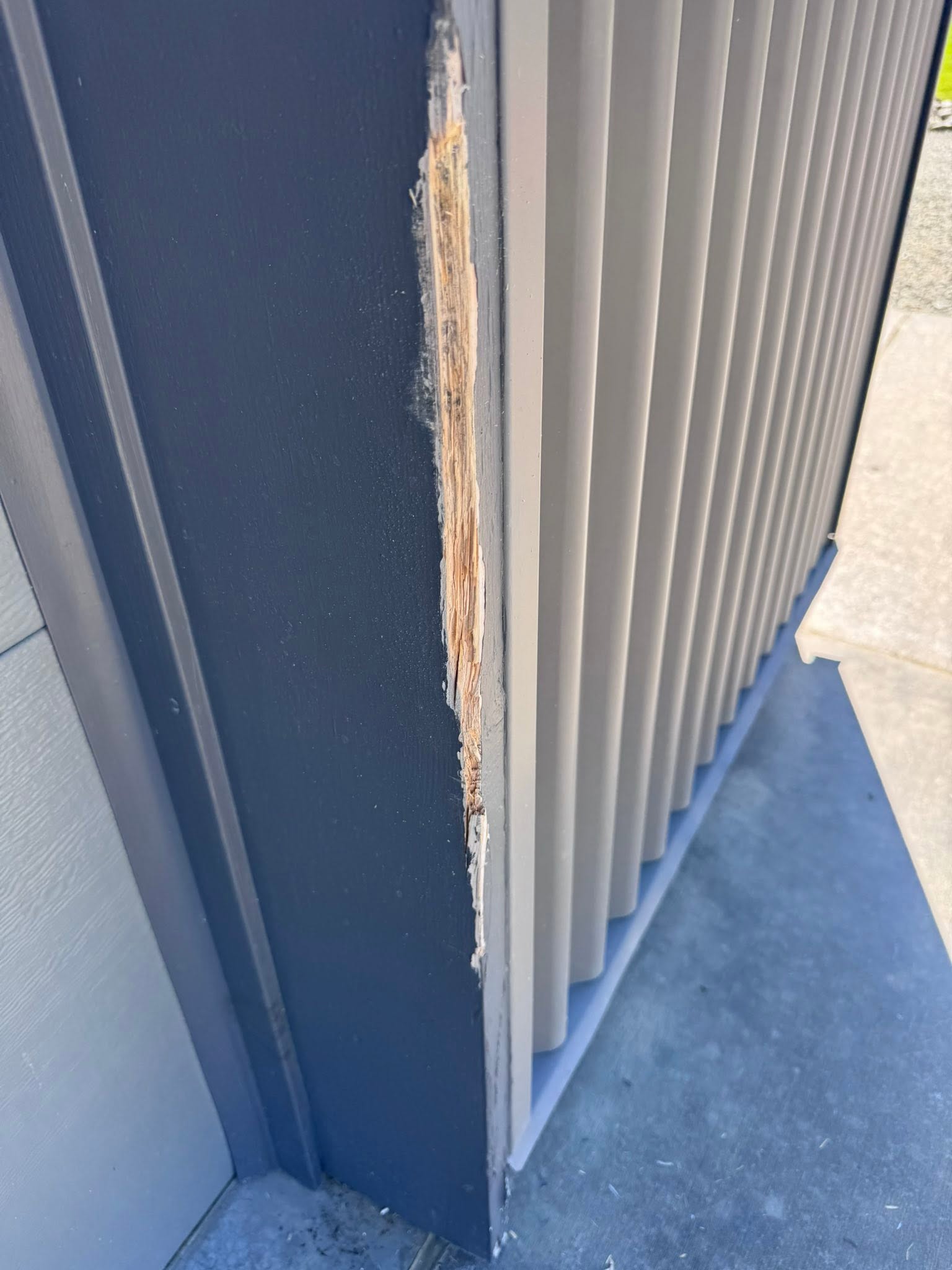 Split, weather-damaged exterior corner trim with raw wood exposed
